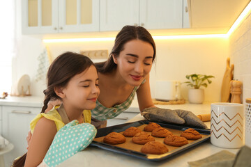 Wall Mural - Mother and daughter with freshly baked cookies in kitchen