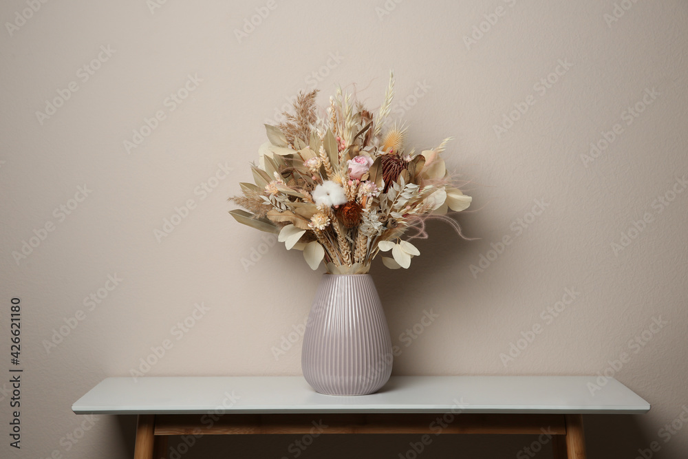 Beautiful dried flower bouquet in ceramic vase on white table near light grey wall - obrazy, fototapety, plakaty 