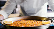 © bodiaphoto - chef holding paella on the table close-up - Spanish food