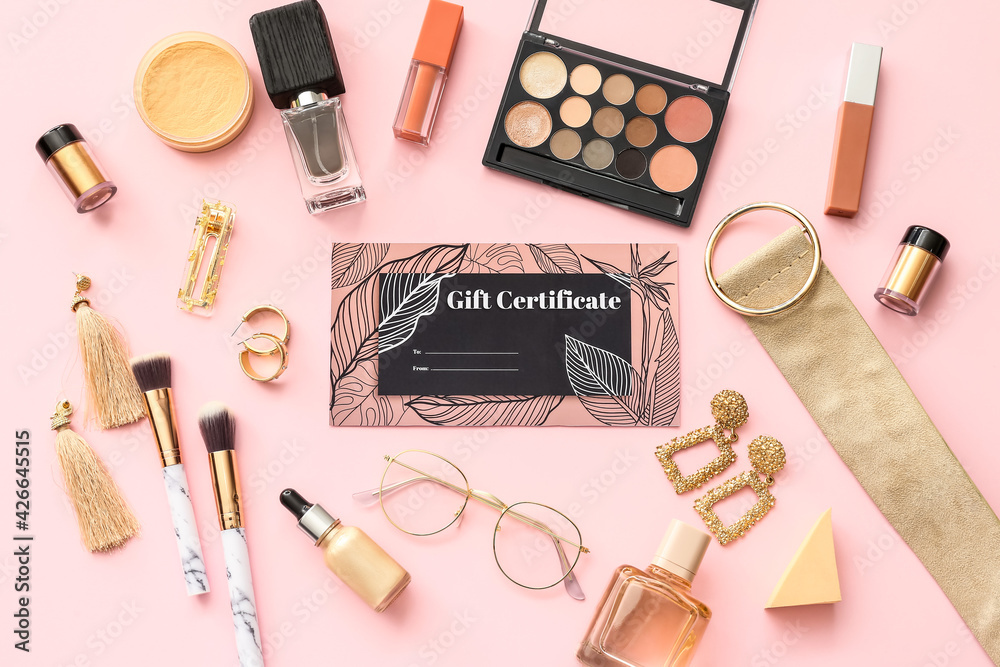 Gift certificate, decorative cosmetics and female accessories on color background