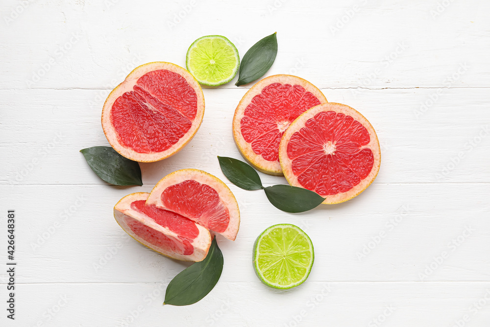 Fresh cut citrus fruits on white wooden background