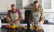 © Wavebreak Media - Happy caucasian senior couple in kitchen wearing aprons preparing food together