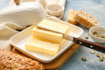 Box with butter, bread and seeds on color background, closeup