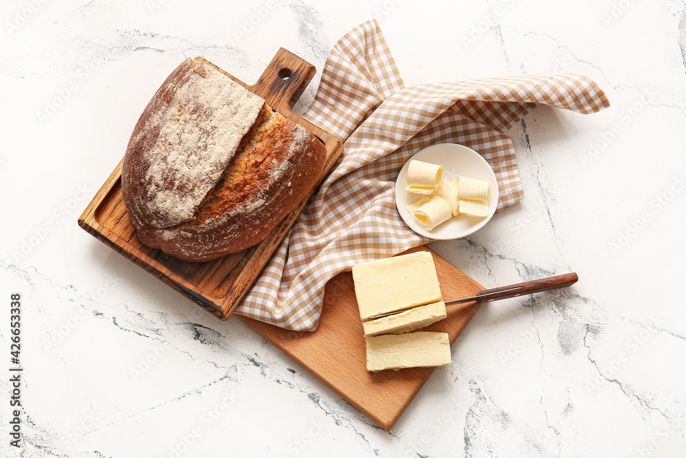 Fresh bread and butter on light background