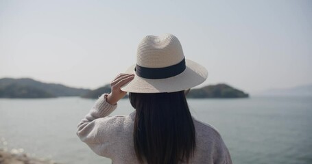 Poster - Woman wear straw hat and look at the sea