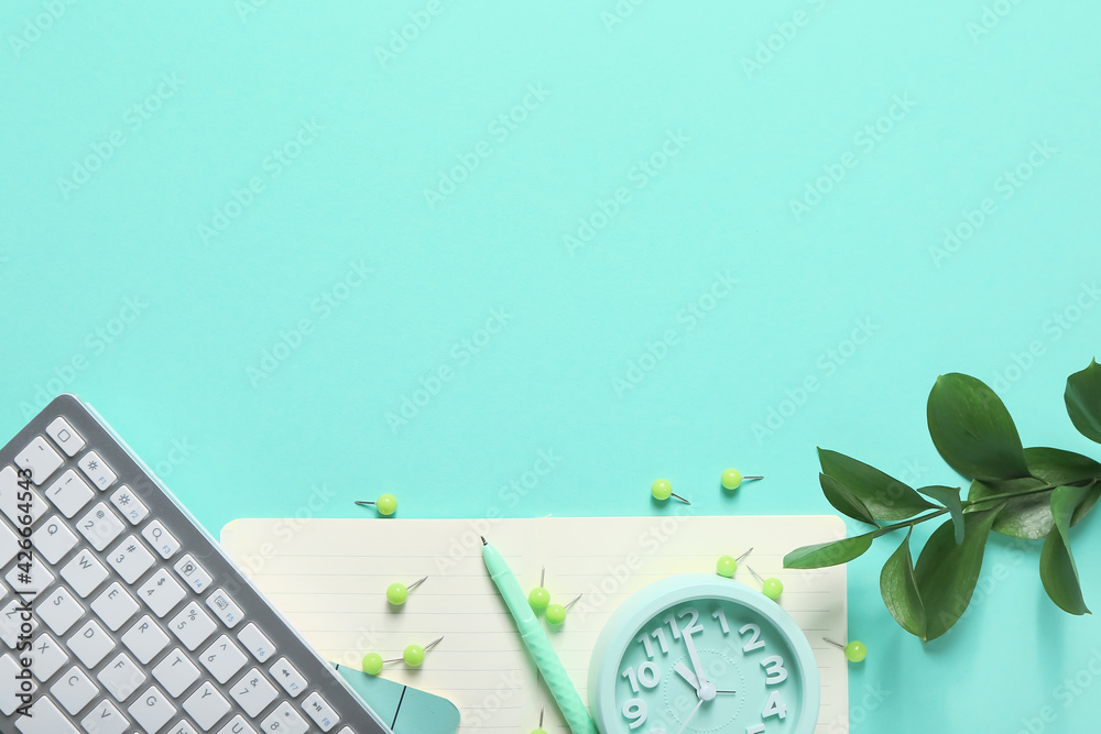 Composition with alarm clock, keyboard and stationery on color background