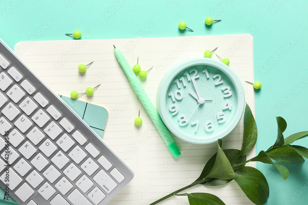Composition with alarm clock, keyboard and stationery on color background