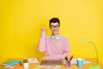 Sticker - Photo of young happy cheerful positive good mood man in glasses has great idea studying at table isolated on yellow color background