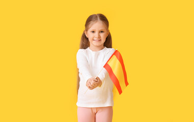 Little girl with the flag of Spain on color background