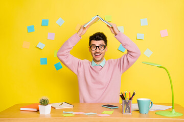 Sticker - Photo of young guy happy smile sit desk table read book put above head enjoy remote study background with paper stickers