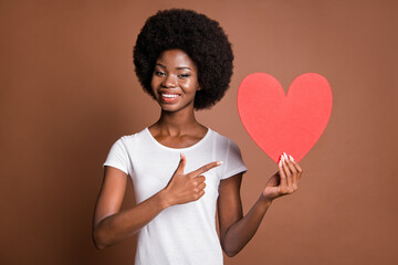 Poster - Photo of promoter girl indicate forefinger red heart figure wear white t-shirt isolated brown color background