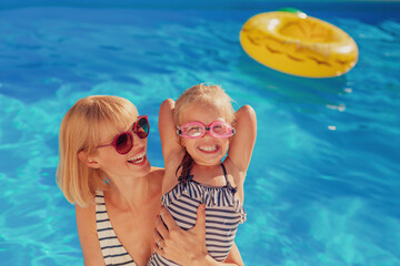 Canvas Print - Mother and daughter having fun at the swimming pool