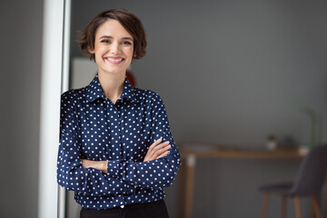 Portrait of attractive content skilled cheerful girl folded arms at work place station indoors