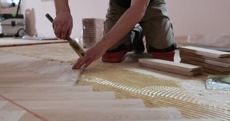 Wall Mural - close up of man installing wood flooring. Construction in a renovated room installation of parquet.