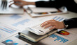 © David - Close up of Businesswoman doing finances,accounting analysis,report,data and pointing graph at the office.