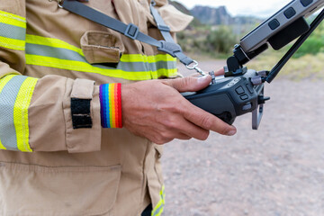 Canvas Print - firefighter ,, with LGBT bracelet, operating drone in search and rescue