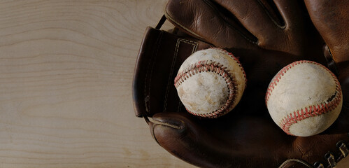 Sticker - baseball glove with old used balls on wood background with copy space.