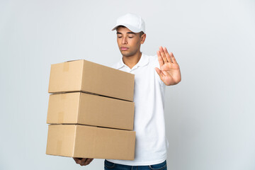 Delivery Brazilian man isolated on white background making stop gesture and disappointed