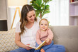 © Louis-Photo - A Young mother is reading a book to her cute daughter.