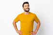 © luismolinero - Young handsome man with beard isolated on white background posing with arms at hip and smiling