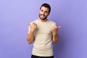 Wall Mural - Young handsome man with beard over isolated background with thumbs up gesture and smiling