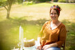 © Martin Barraud/Caia Image - Portrait happy woman enjoying cake at table in sunny summer garden