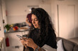 © Sam Edwards/Caia Image - Woman using smart phone at home