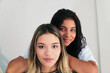 © Hector Pertuz - Portrait of two cheerful young girls standing together and looking at the camera.