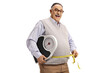 Corpulent mature man smiling and holding a scale and a measuring tape