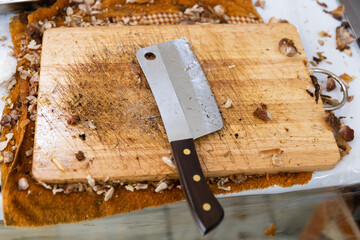 Dirty stainless steel cleaver on wooden chopping board