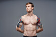 © SHOTPRIME STUDIO - sport man cropped view workout tattoo on arms gray background