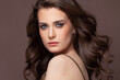 © millaf - Portrait of beautiful model woman brunette with clear skin and healthy wavy hair. Pretty woman with natural makeup on brown
