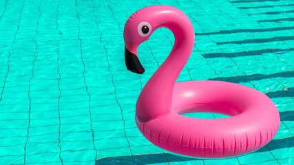 Summer holiday poster. Pink inflatable flamingo in pool water for summer beach background. Funny bird toy for kids.