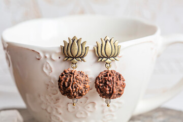 Wall Mural - lotus and Indian seed earrings on white cup background