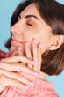 © Анастасия Каргаполов - Beauty concept, pretty woman with bright pink nail color manicure on background of warm sweater and blue wall, spring mood
