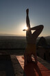 Woman meditating against the sun at sunrise in the morning in Cappadocia in Turkey.