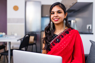 business women in sari laptop working in living room at home