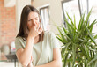 © kues1 - pretty woman feeling disgusted, holding nose to avoid smelling a foul and unpleasant stench