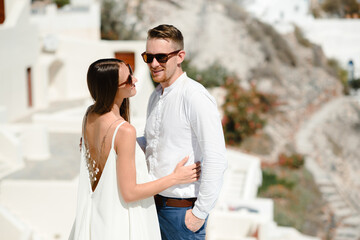 Happy couple hugging and laughing together with a view of Santorini