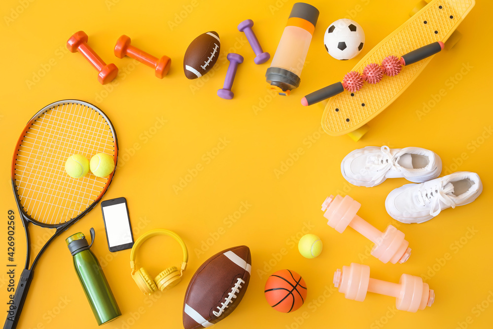 Frame made of sport equipment on color background