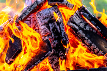 A large fire made of planks. Firewood in a bright flame. Burning wood and hot flames.