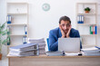 © Elnur - Young male employee unhappy with excessive work in the office
