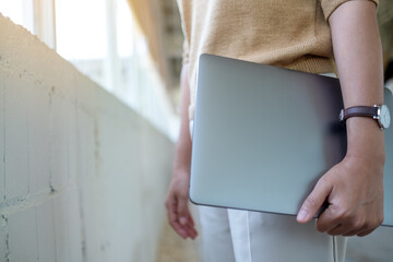 Closeup image of a woman holding laptop computer