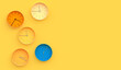 Simple multicolor wall clock with different time on yellow background