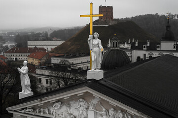 Wall Mural - Historical Statue with gold cross on the cathedral roof with hill and castle ruins in background 