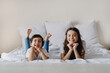 © Olena Bloshchynska - Cute children lying on white bed.