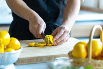 Woman cutting lemons in kitchen.

