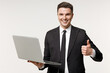 © ViDi Studio - Young employee business corporate lawyer man wearing classic formal black grey suit shirt tie work in office hold laptop pc computer show thumb up gesture isolated on white background studio portrait