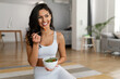 Young woman eating a healthy salad after workout. Fitness and healthy lifestyle concept.