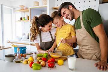 Wall Mural - Happy family preparing healthy food together in kitchen